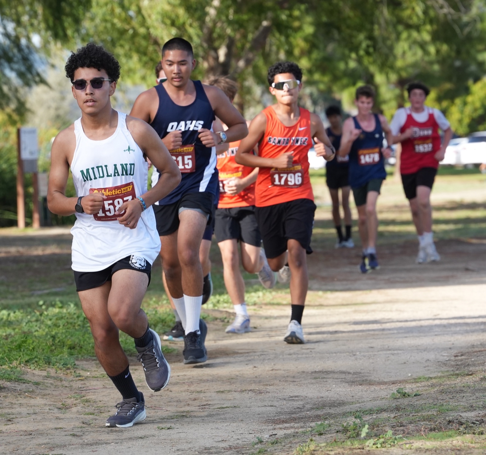 A Midland cross-country runner leading a pack of runners on a dirt course